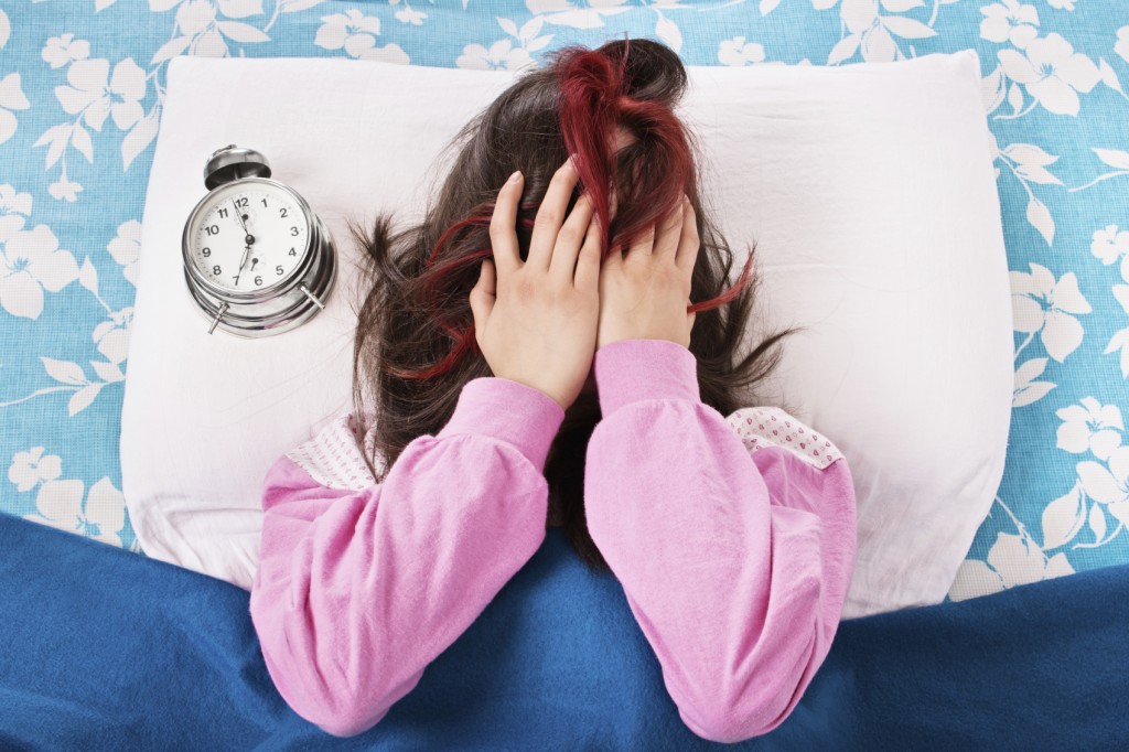 Young girl annoyed by the alarm clock