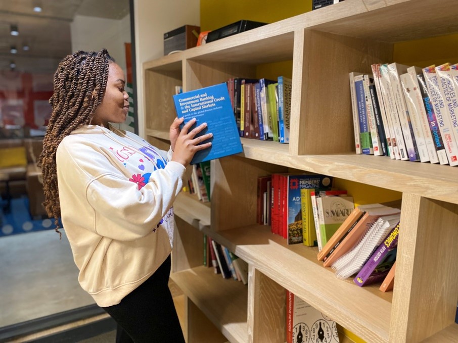 student putting book away in cityblock library