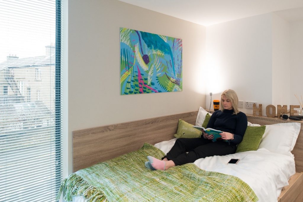 women, reading book in her accommodation, in bed