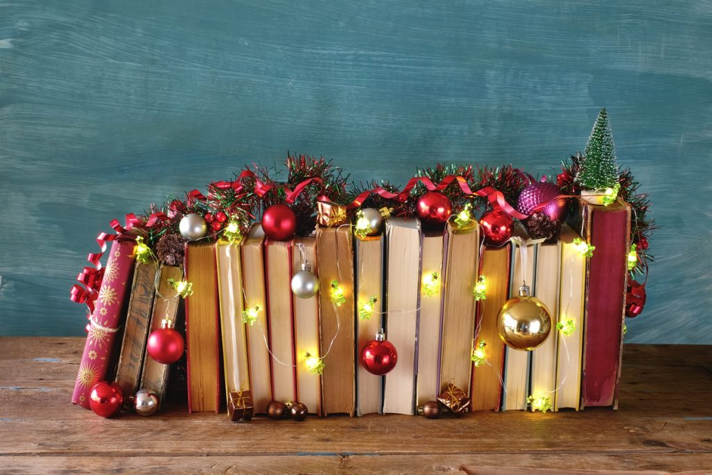 Books covered in baubles, fairy lights, and christmas decorations