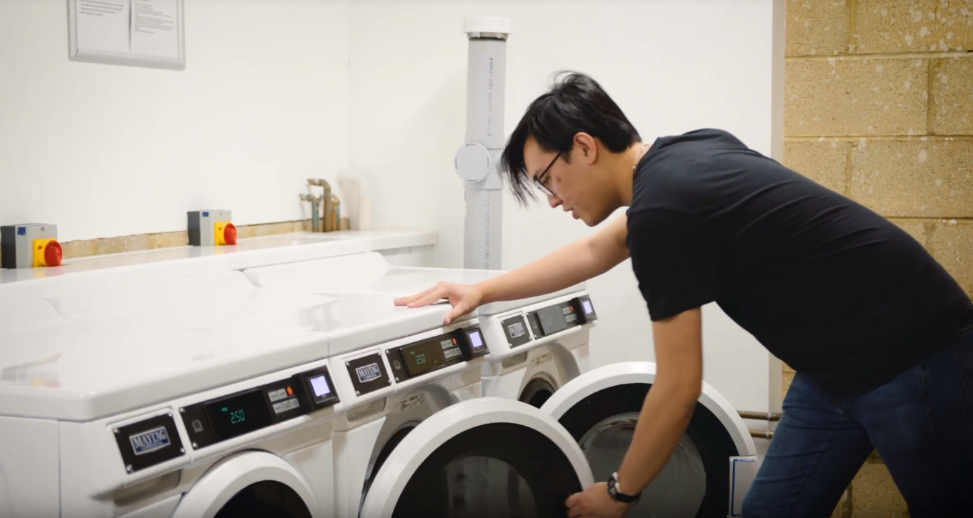 Student using communal washing machines