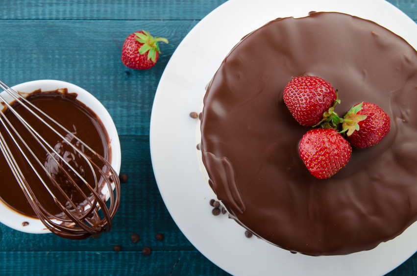 The process of making Cake. Chocolate ganache frosting with strawberry. Top view.