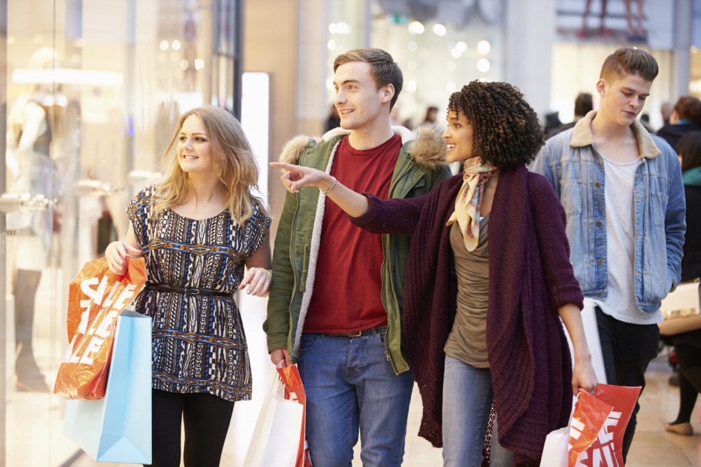 Group Of Young Friends Shopping In Mall Together